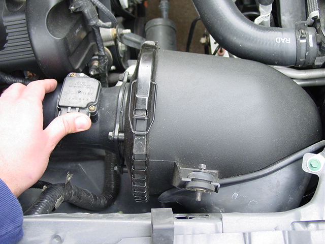 Carefully remove the harness plug on the mass air sensor. Remove the single bolt that attaches the air box to the fender. Slide out the entire air box and sensor assembly.