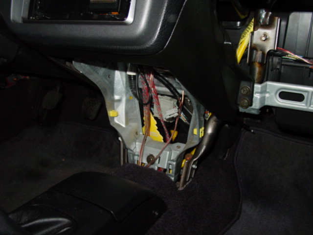 Remove the console below the radio. There are two screws under the radio and one on each side. There is also one harness plug that must be disconnected before you pull the console out.
