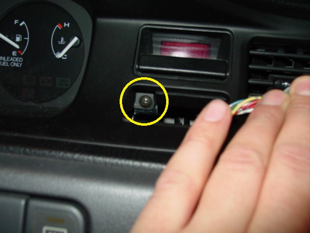 Pop the hazard button by prying it out with a screwdriver. Under the button is a screw that needs to be removed. There are two more screws that need to be removed just above the instrument cluster.